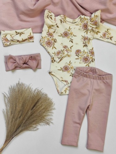 Płaskie ujęcie zestawu ubranek handmade: kremowe body w kwiaty z falbankami, brudno-różowe legginsy i dopasowane opaski na głowę, ułożone na białym tle z dodatkiem pampasu.