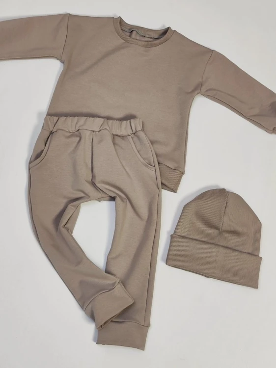 Beżowy komplet dresowy basic dla dzieci: bluza, spodnie z kieszeniami i czapka beanie.