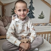 chłopiec w bluzie z kapturerm, prehistoryczne zwierzęta: tygrys szablozębny, mamuty